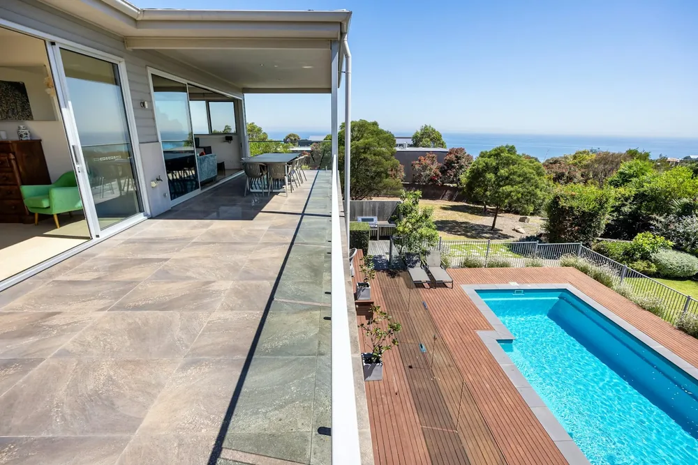 Glass pool fence on a coastal Bellarine property — the barrier a registered pool certifier checks during a Form 23 inspection