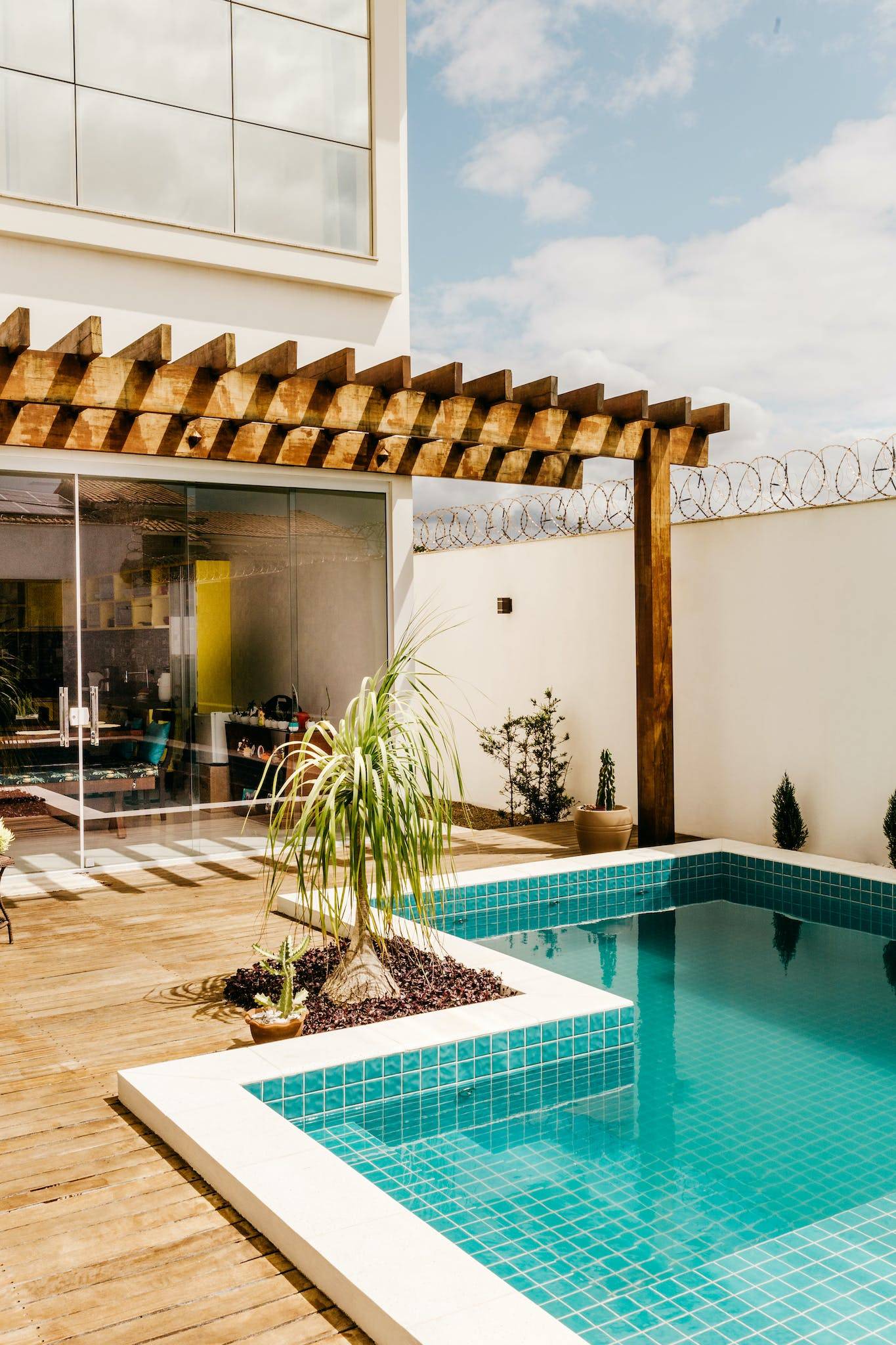 Contemporary interior of lounge area with swimming pool located on terrace of luxury villa in sunny day
